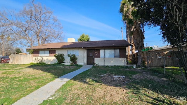 view of front of property featuring a front yard, fence, a chimney, and stucco siding