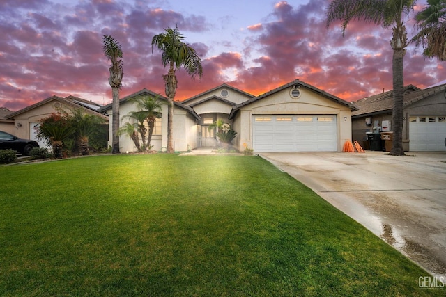 view of front facade with a front lawn, a garage, driveway, and stucco siding