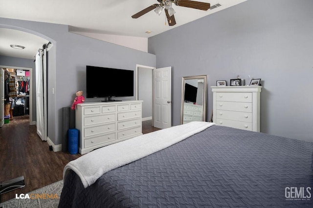 bedroom featuring visible vents, a barn door, arched walkways, dark wood-style flooring, and vaulted ceiling