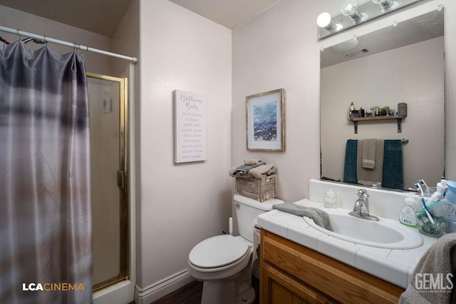 bathroom with visible vents, toilet, a stall shower, and vanity