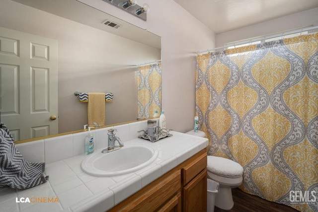 bathroom with vanity, toilet, and visible vents