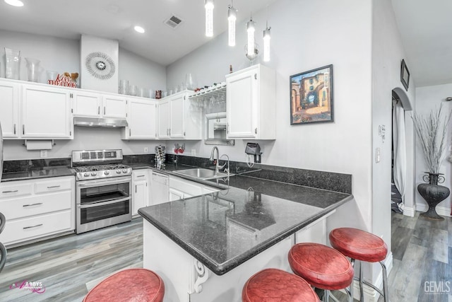 kitchen with a breakfast bar, sink, white cabinetry, double oven range, and pendant lighting