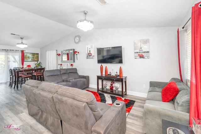 living room featuring lofted ceiling and light hardwood / wood-style floors