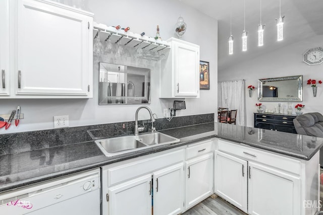 kitchen with sink, hanging light fixtures, white dishwasher, kitchen peninsula, and white cabinets