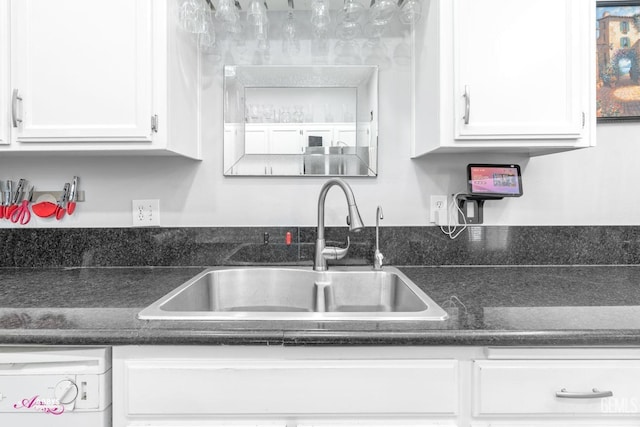 kitchen featuring white cabinetry, sink, and dishwashing machine