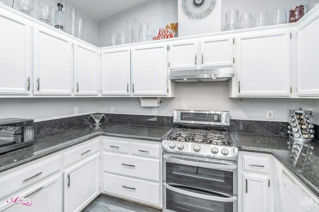 kitchen featuring white cabinetry, double oven range, dark stone countertops, and white dishwasher