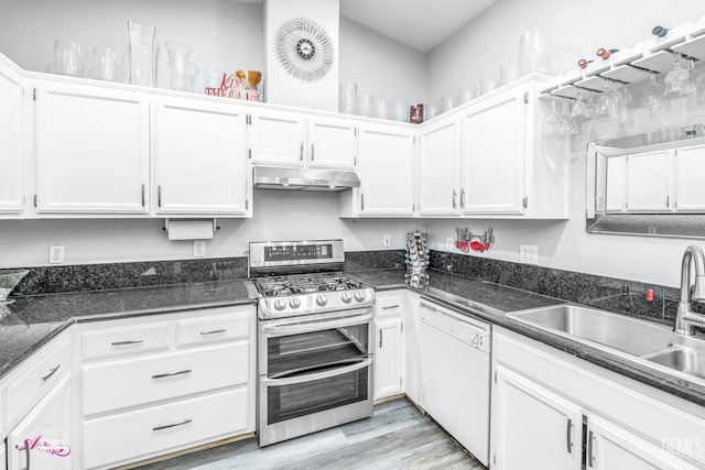 kitchen featuring sink, dark stone countertops, white cabinets, double oven range, and white dishwasher