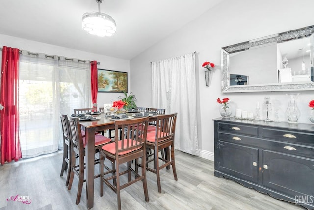 dining room featuring vaulted ceiling and light hardwood / wood-style floors