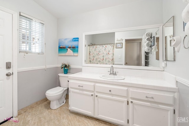 bathroom featuring vanity, curtained shower, and toilet