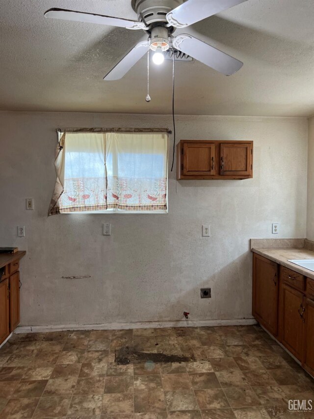 kitchen featuring ceiling fan, white appliances, kitchen peninsula, and a textured ceiling