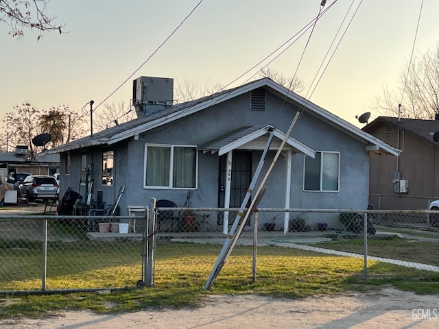 bungalow featuring central AC and a lawn