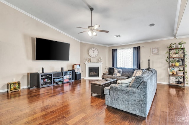 12503 Maclure Dr, Bakersfield, CA 93311 - living room featuring ceiling fan, wood finished floors, vaulted ceiling, ornamental molding, and a glass covered fireplace