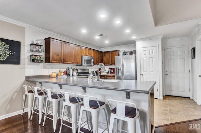 12503 Maclure Dr, Bakersfield, CA 93311 - kitchen with stainless steel appliances, a peninsula, dark countertops, ornamental molding, and recessed lighting