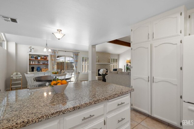 2700 Hoad Ln, Bakersfield, CA 93309 - kitchen featuring white cabinets, light stone countertops, light tile patterned floors, beamed ceiling, and ornate columns