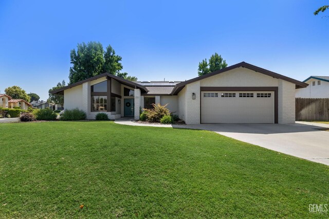 2700 Hoad Ln, Bakersfield, CA 93309 - view of front of property with roof mounted solar panels, an attached garage, brick siding, and driveway