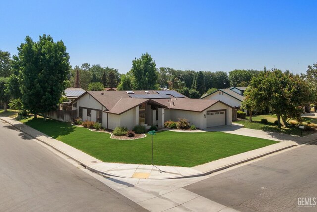 2700 Hoad Ln, Bakersfield, CA 93309 - view of front of property featuring concrete driveway, a front lawn, a garage, roof mounted solar panels, and stucco siding