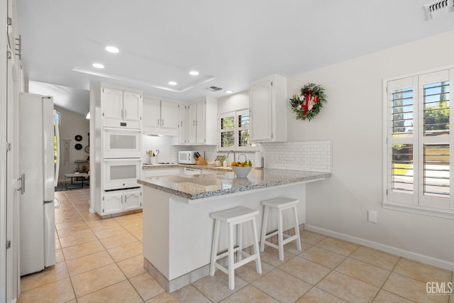 2700 Hoad Ln, Bakersfield, CA 93309 - kitchen with white appliances, a peninsula, recessed lighting, backsplash, and light tile patterned flooring