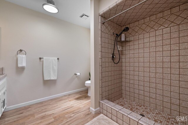 2700 Hoad Ln, Bakersfield, CA 93309 - bathroom featuring toilet, wood finished floors, tiled shower, and baseboards