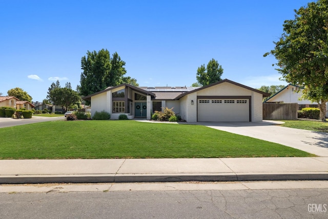 2700 Hoad Ln, Bakersfield, CA 93309 - view of front facade with roof mounted solar panels, an attached garage, concrete driveway, and brick siding