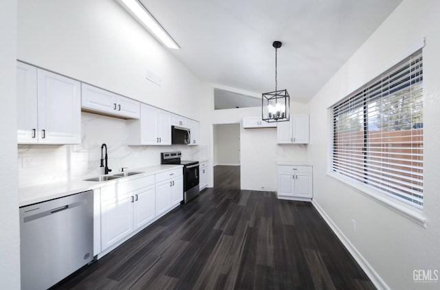 kitchen featuring light countertops, backsplash, appliances with stainless steel finishes, white cabinets, and a sink