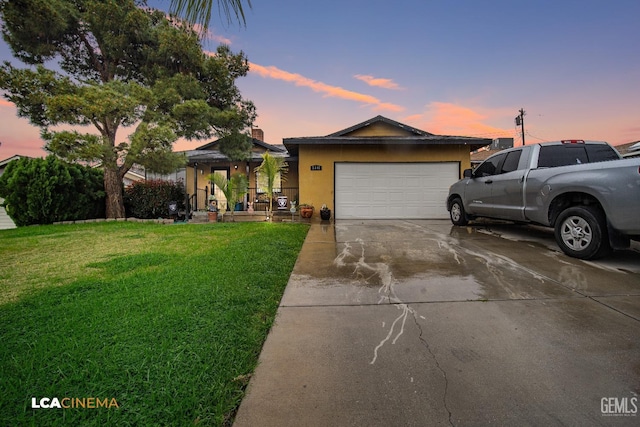 view of front of property with a front lawn, an attached garage, driveway, and stucco siding