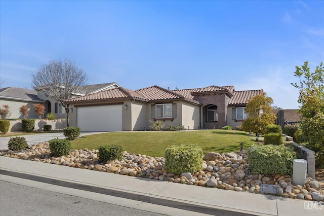 mediterranean / spanish-style home with concrete driveway, a front yard, a tiled roof, and stucco siding