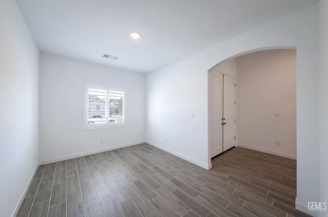 4414 Coal Rock Ct, Bakersfield, CA 93313 - spare room with arched walkways, dark wood-style floors, and baseboards