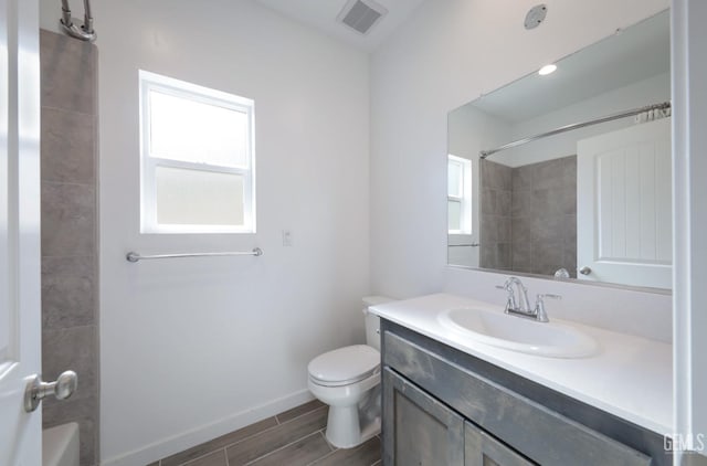 4414 Coal Rock Ct, Bakersfield, CA 93313 - bathroom featuring toilet, vanity, wood finish floors, baseboards, and shower / washtub combination