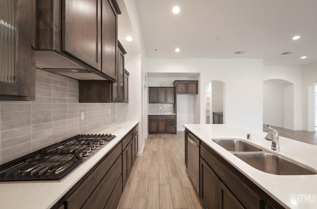 4414 Coal Rock Ct, Bakersfield, CA 93313 - kitchen with a sink, arched walkways, dark brown cabinetry, recessed lighting, and decorative backsplash