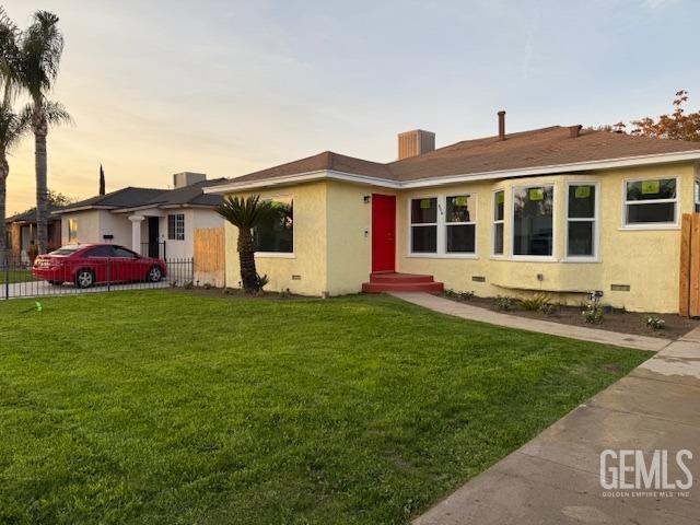 single story home featuring a lawn