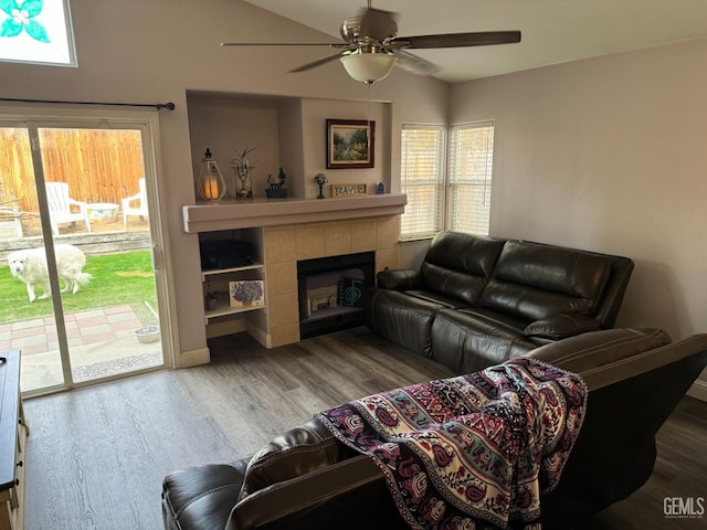 living room with hardwood / wood-style flooring, ceiling fan, a healthy amount of sunlight, and a tiled fireplace