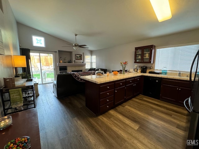 kitchen featuring kitchen peninsula, tile countertops, dishwasher, dark hardwood / wood-style floors, and lofted ceiling