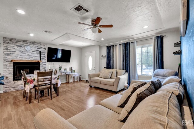1504 Stockton Ave, Bakersfield, CA 93308 - living room with a textured ceiling, ceiling fan, light wood-style floors, a fireplace, and recessed lighting