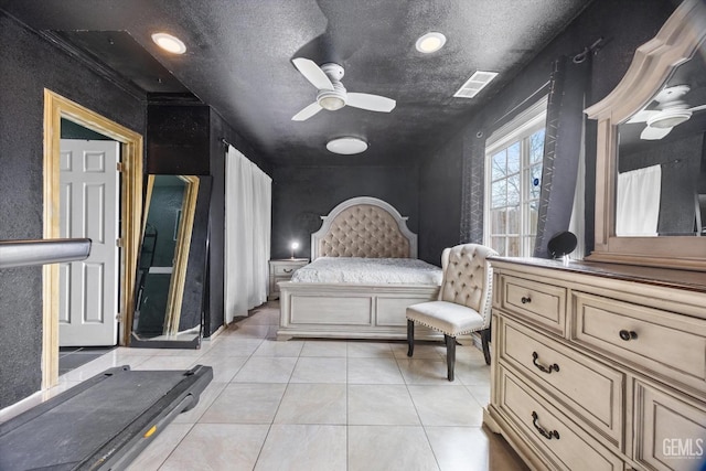 bedroom featuring light tile patterned floors, visible vents, and a textured ceiling