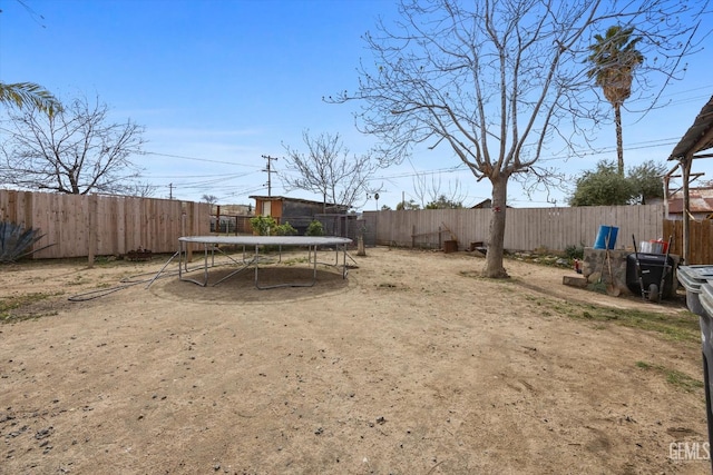 view of yard featuring a fenced backyard and a trampoline