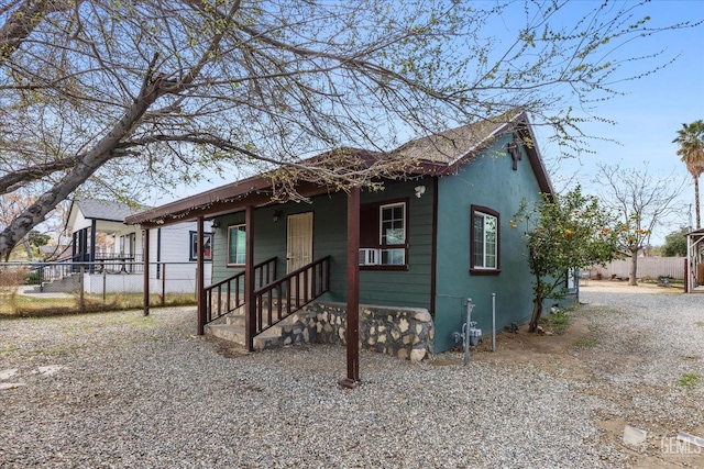 bungalow-style home with fence and stucco siding