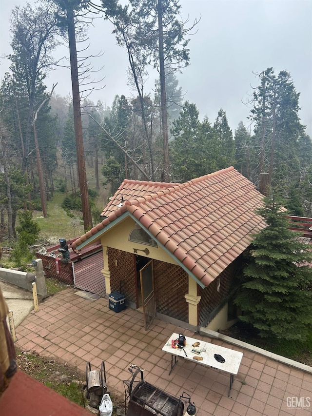 47701 Sugarloap Loop, Posey, CA 93260 - view of home's exterior featuring a tile roof, a patio area, a view of trees, and brick siding