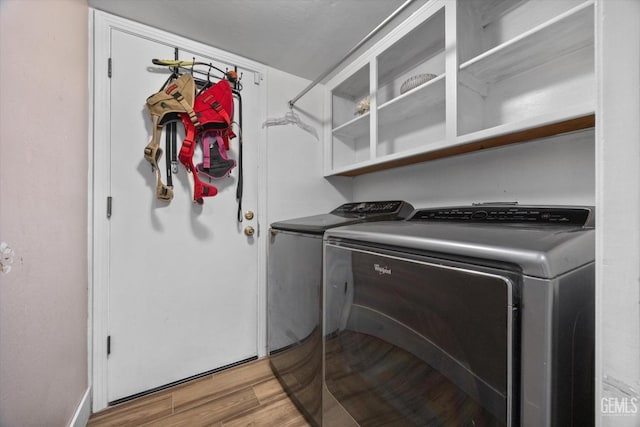 laundry room featuring laundry area, separate washer and dryer, and light wood-style flooring