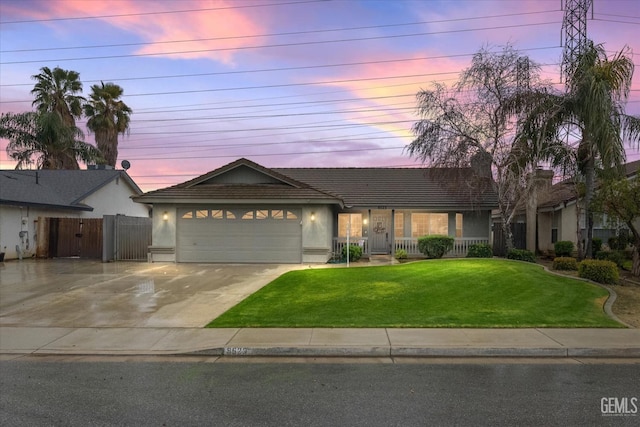 ranch-style house with an attached garage, fence, concrete driveway, stucco siding, and a front lawn