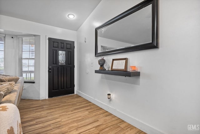 foyer featuring light wood finished floors and baseboards