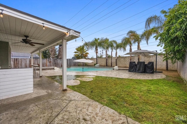 view of yard with a patio, a fenced backyard, a ceiling fan, and a fenced in pool