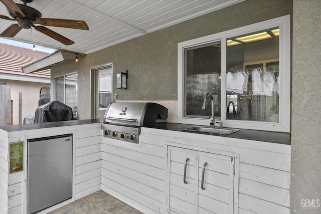 view of patio featuring an outdoor kitchen, ceiling fan, grilling area, and a sink