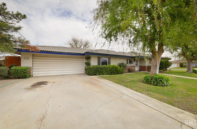 ranch-style house with a garage, a front lawn, concrete driveway, and stucco siding