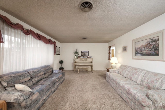 living area with visible vents, a textured ceiling, and carpet flooring