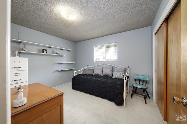 bedroom featuring light carpet, a textured ceiling, and a closet