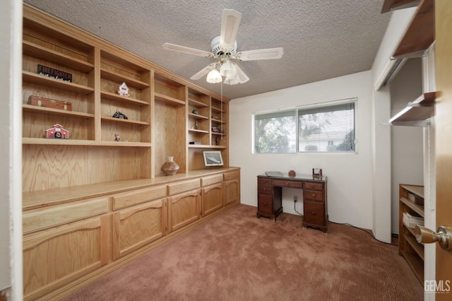 home office featuring a textured ceiling, ceiling fan, and light colored carpet