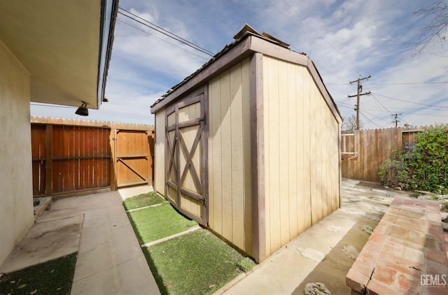 view of shed featuring a gate and fence