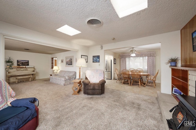 carpeted living room with visible vents and a textured ceiling