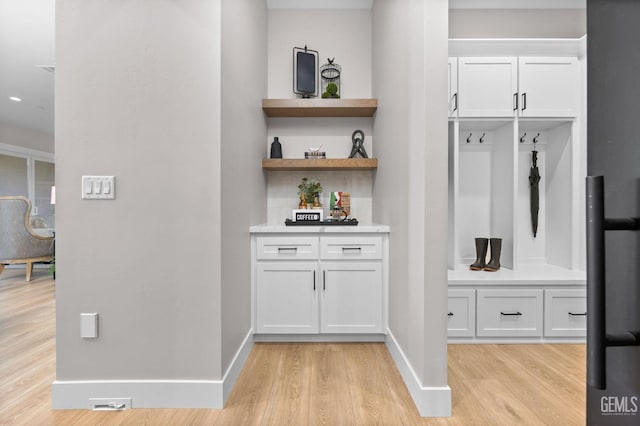 interior space with light wood-type flooring and white cabinetry