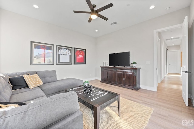 living room with light hardwood / wood-style flooring and ceiling fan